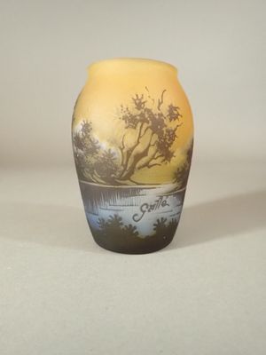 un petit vase avec un tableau posé sur une table