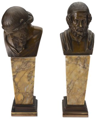 une paire de bustes en bronze représentant un homme et une femme, posés sur des socles en marbre