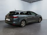 the rear end of a grey car in a white room