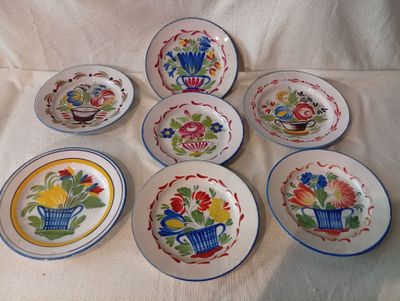 six assiettes ornées de motifs différents, disposées sur une nappe blanche