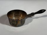 a small metal cup with a wooden handle on a table