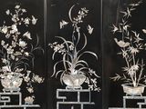 three black panels with white flowers and birds on them