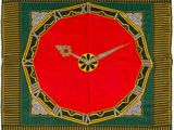 une image représentant une horloge rouge posée sur une nappe verte et jaune