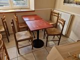 a table and chairs in a small room with a window