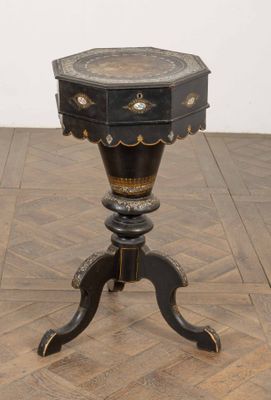 une petite table munie d'un tiroir, posée sur un parquet