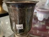 une coupe en argent posée sur une table en verre, avec une étiquette de prix dessus