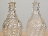 two glass bottles that are sitting on a table