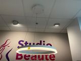une grande enseigne portant l'inscription « Studio Beauure » accrochée au mur