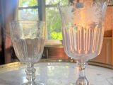 two wine glasses sitting on a table in front of a window
