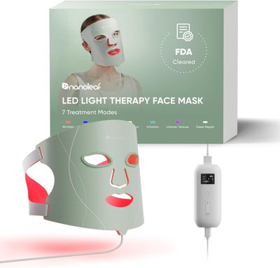 une boîte contenant un masque facial de luminothérapie à LED, à côté d'une boîte blanche