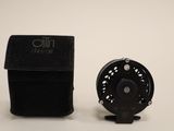 a small black box with a black fly reel next to it