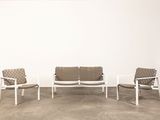 trois chaises et un canapé dans une pièce aux murs blancs