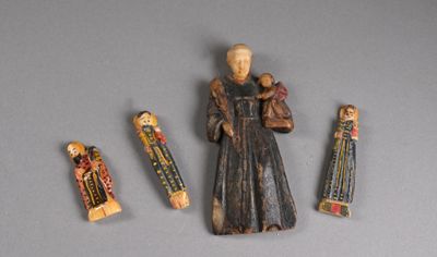 une figurine représentant un homme tenant un bébé dans ses bras et trois autres figurines