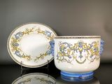 une tasse et une soucoupe posées sur une table à côté d'une assiette
