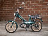 a small child ' s bike parked in front of a brick wall