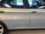 a silver car parked in a garage with its door open