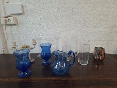 quatre vases en verre bleu posés les uns à côté des autres sur une table