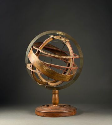 a wooden and metal globe on a stand with a black background
