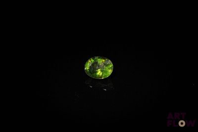 gros plan d'un diamant vert sur une surface noire
