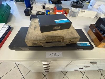 a stack of books on a table with a laptop on top