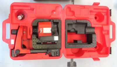 deux outils rouges dans un étui rouge posé sur une surface blanche