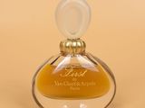 an image of a bottle of perfume sitting on top of a table