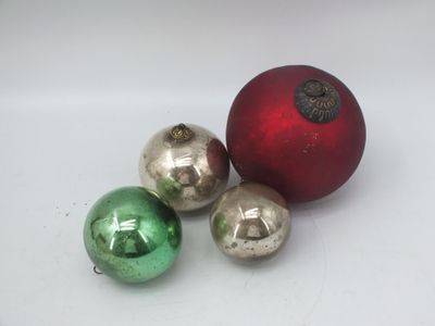 trois boules de Noël brillantes posées sur une surface blanche