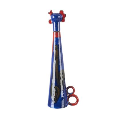 un vase bleu muni d'une anse rouge et contenant une paire de ciseaux