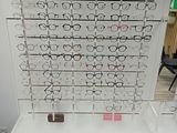 un présentoir de lunettes dans un magasin, sur lequel sont disposées de nombreuses paires de lunettes
