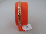 an orange bang bracelet with a gold plated design on it