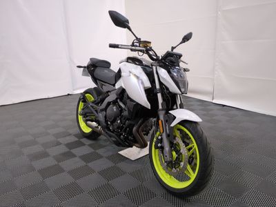 a picture of a white and yellow motorcycle parked on a black and white checkered floor