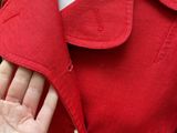 the woman is wearing a red jacket with buttons on it