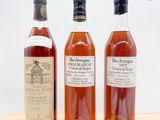 trois bouteilles de vin sont posées sur une table devant un fond blanc