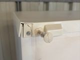 gros plan d'une poignée de porte sur un meuble blanc