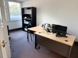 un bureau sur lequel se trouvent deux ordinateurs, dans une pièce