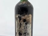 une vieille bouteille de vin posée sur une table