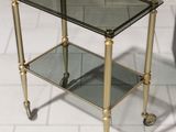 a small glass table with wheels on the floor
