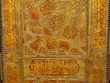 an old book with gold and red designs is on display