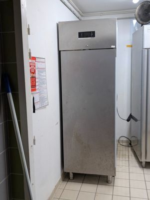 une photo d'une cuisine avec un réfrigérateur et un ventilateur