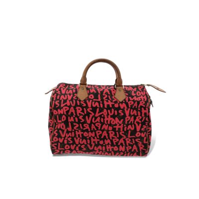 un sac de voyage rouge et noir posé sur une surface blanche