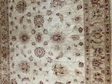 beige and brown oriental rug with a floral design on a white background
