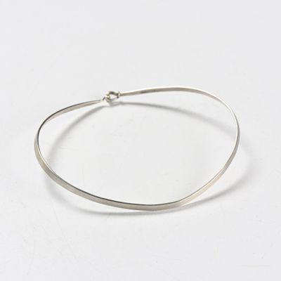 a close up of a silver bracelet on a white surface