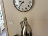 a clock on the wall next to a lamp on a table