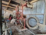 une photo d'un homme travaillant sur une machine dans une grange
