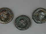 trois pièces de monnaie romaines anciennes posées les unes à côté des autres sur une table