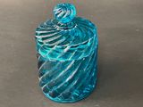 a blue glass jar with a glass lid on a table