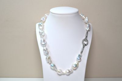 pearl necklace with a silver clasp on a white mannequin