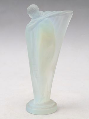 un vase ancien en verre dépoli surmonté d'une figurine