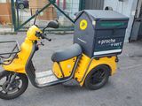 a yellow scooter with a box on the back of it