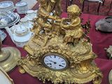 une table sur laquelle se trouvent une horloge dorée et de nombreux autres objets